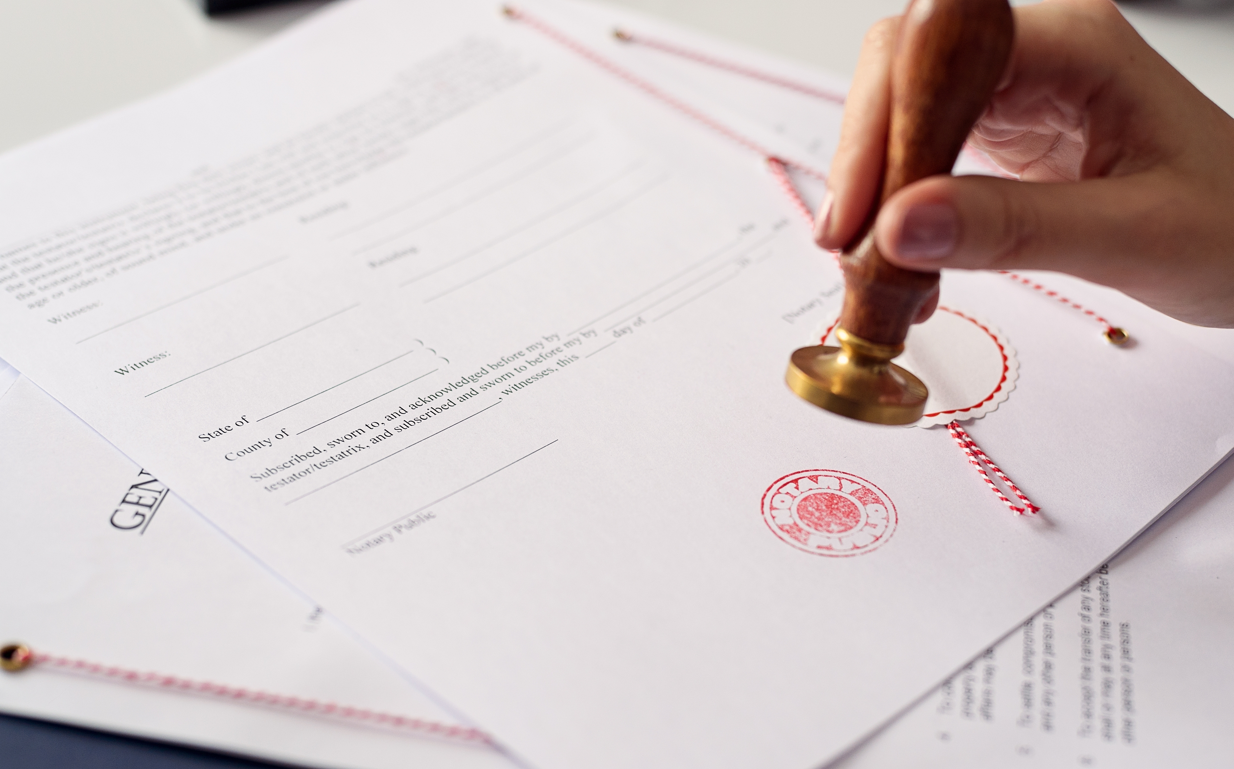 Close up on woman's notary public hand ink stamping the document.